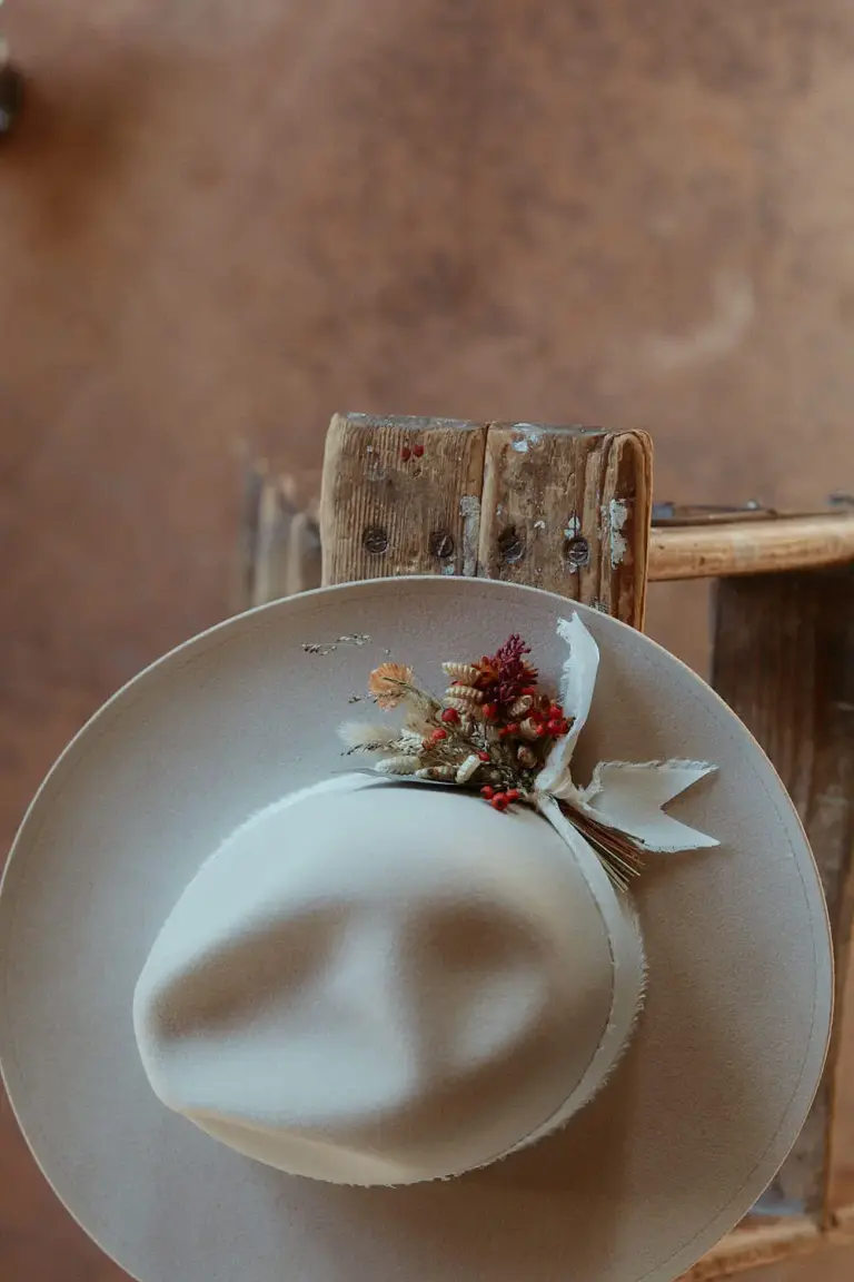 Light hat with dried flowers on a wooden bench – detail photo for branding, photographer St.Gallen