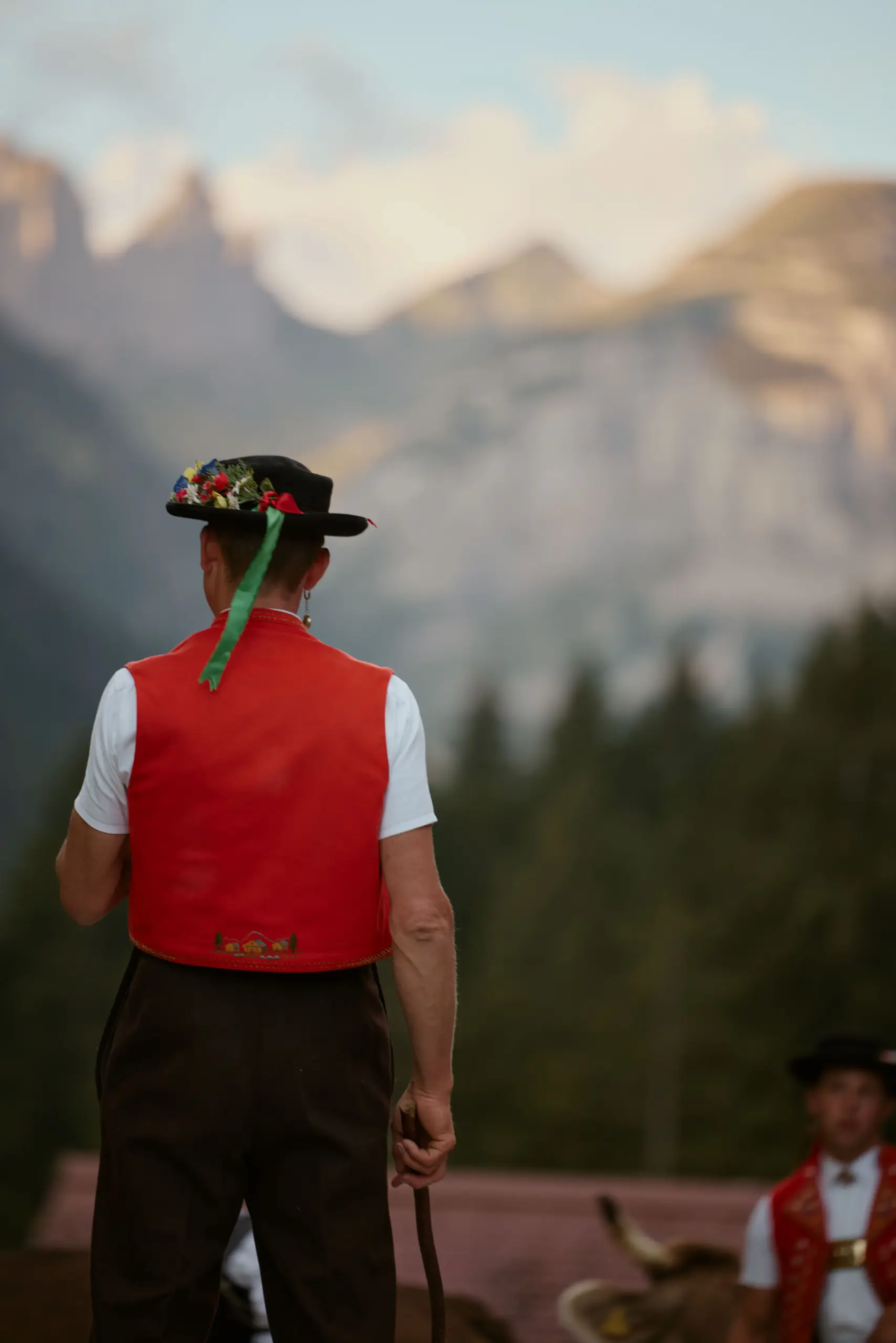 Man mit Appenzellertracht und Hut steht mit dem Rücken zugewandt zum Betrachter beim Sämtisersee.