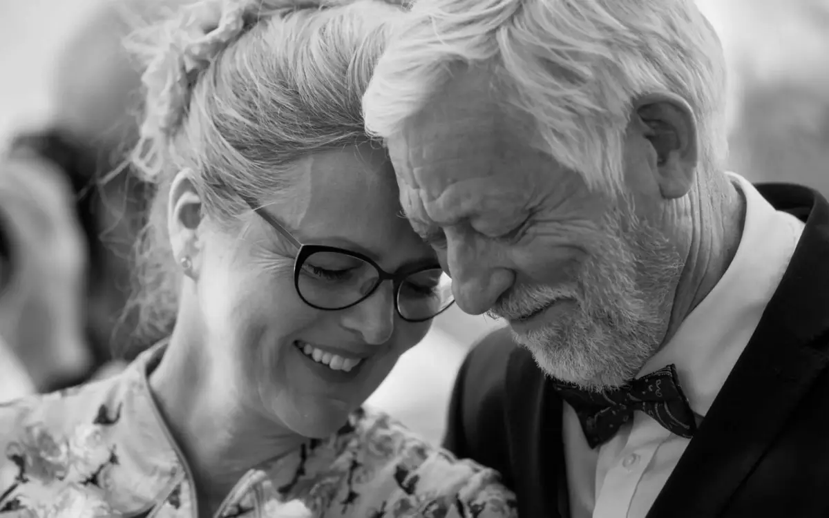 Hochzeitsfotograf St.Gallen & Ostschweiz 5 Älteres Paar nahe beieinander, lachen beide, Mann hat einen Bart und eine Fliege.