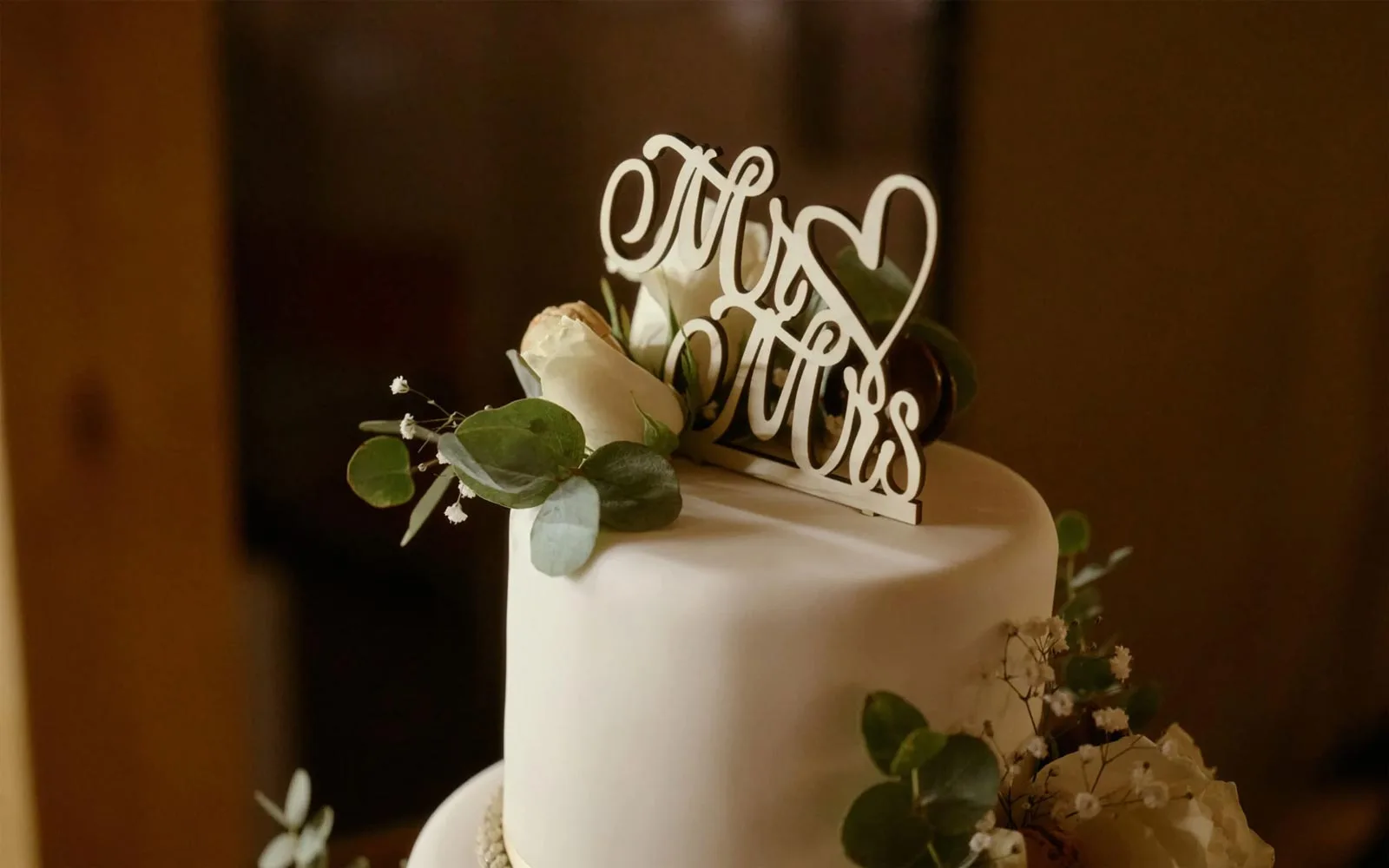 Hochzeitsfotograf St.Gallen & Ostschweiz 26 Mr und Mrs aus Holz geschnitzt, verziert eine Hochzeitstorte.