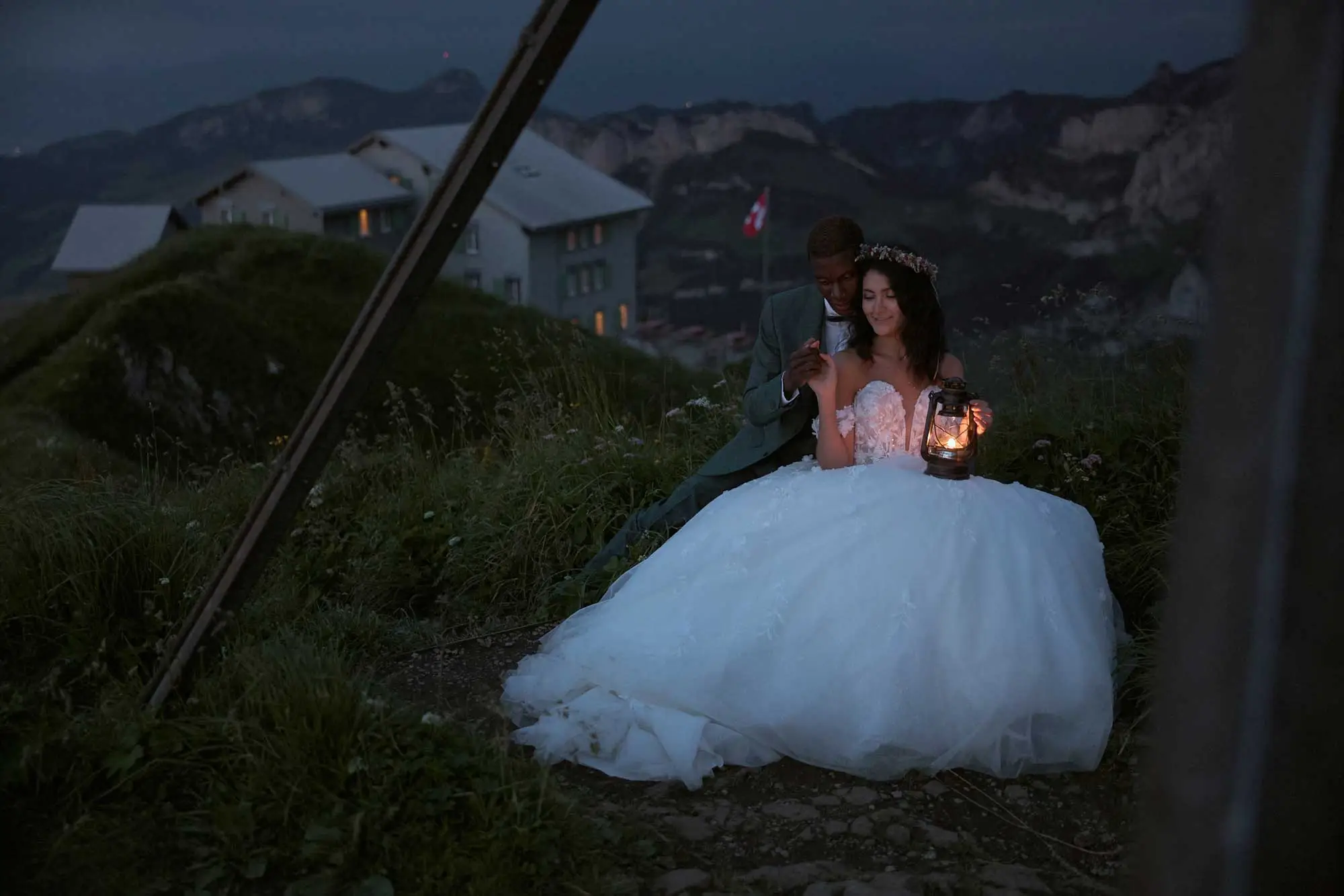 Brautpaar mit Laterne am Hang unter dem Berggasthaus Schäfler in der Dämmerung, Hochzeit in den Bergen