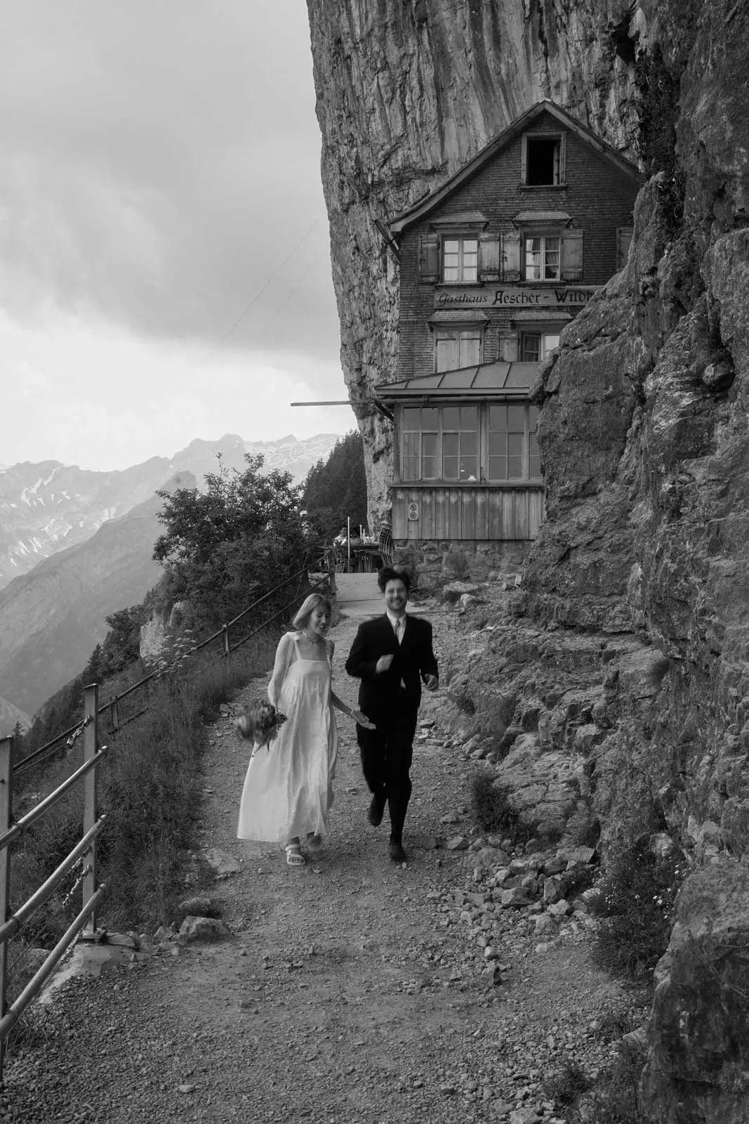 Brautpaar spaziert unterhalb des Berggasthauses Äscher, Hochzeit in Appenzell (Schwarzweiss)