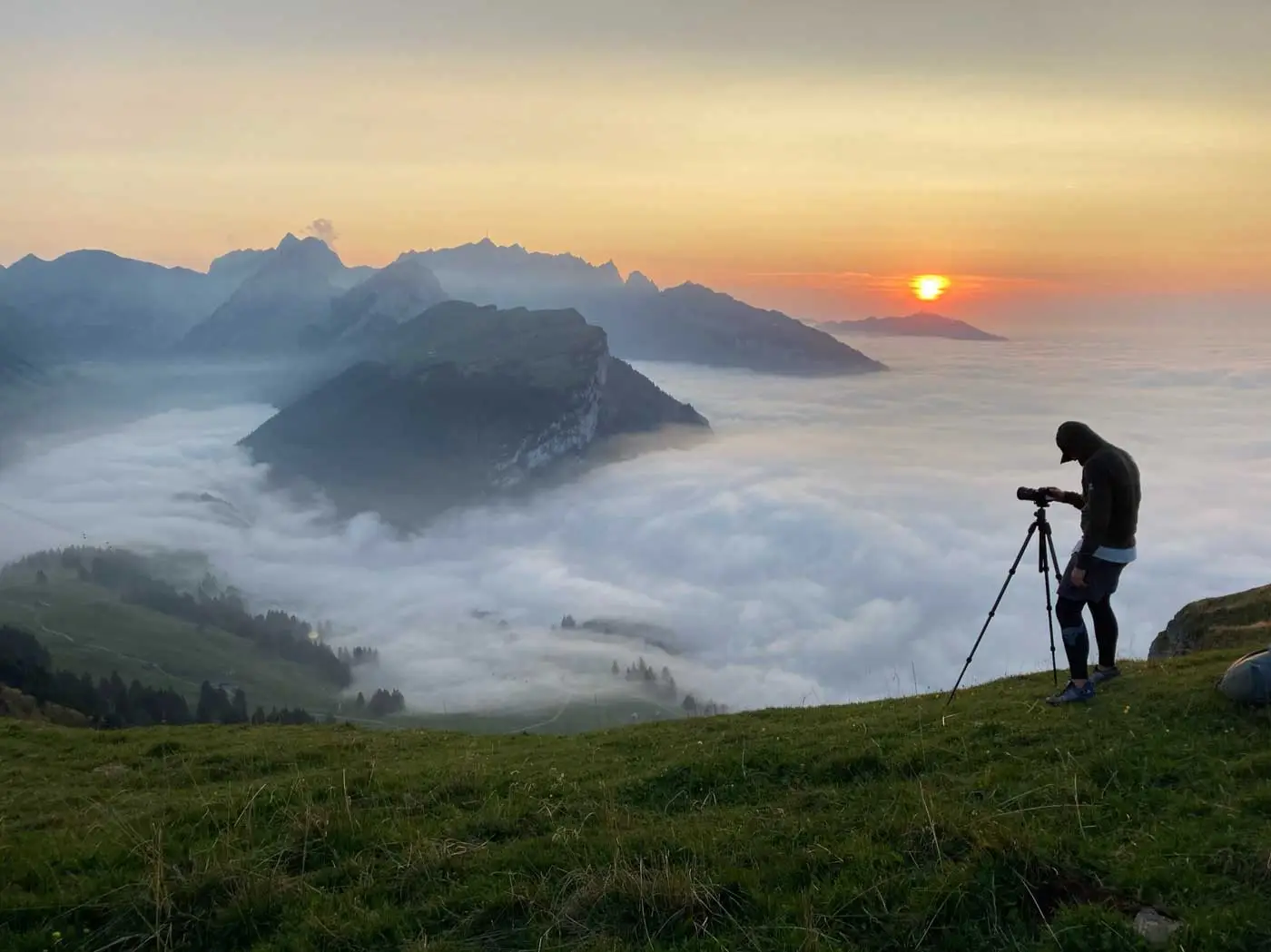 Chris mit Stativ über dem Nebelmeer bei Sonnenuntergang, Appenzell