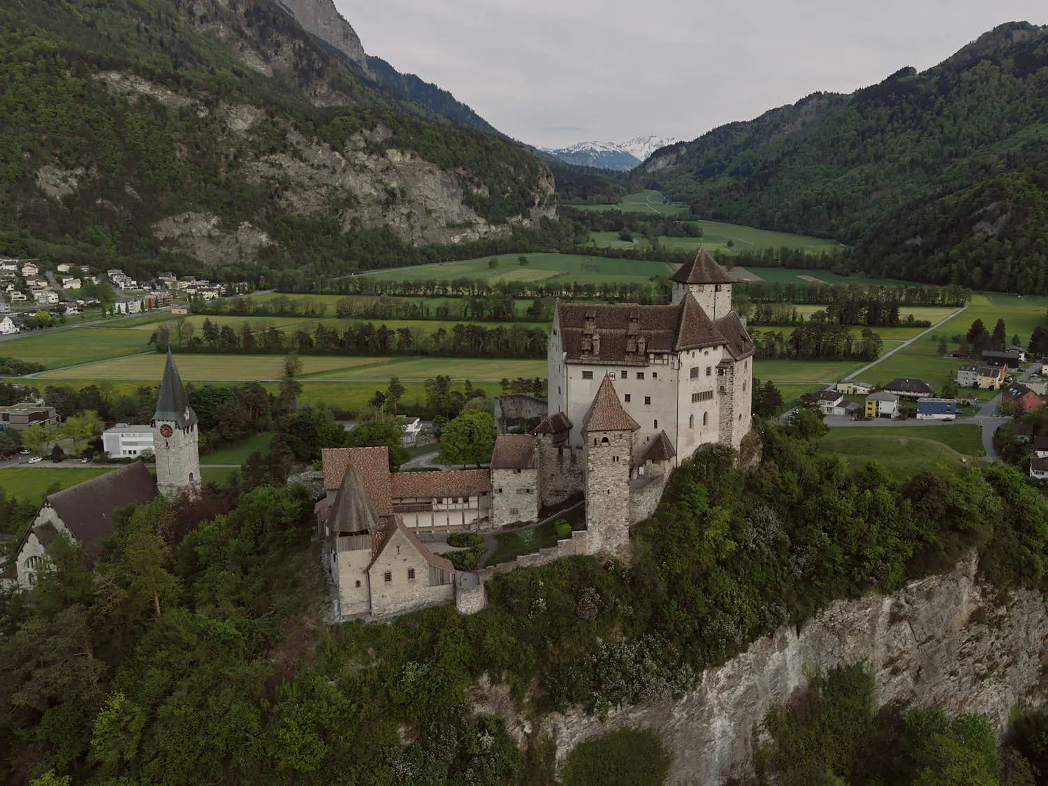 Burg Gutenberg auf dem Felsen über Balzers, Luftaufnahme mit Rheintal und Bergen – Hochzeitslocation in Liechtenstein