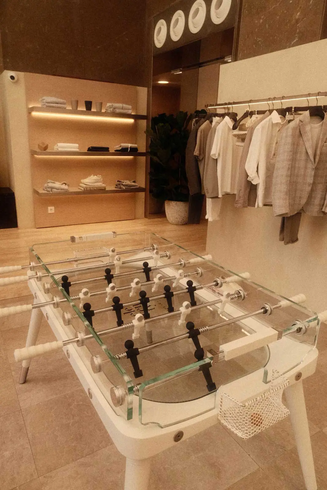 Fashion boutique with a glass table football and clothes rail – branding photos for businesses, photographer St.Gallen