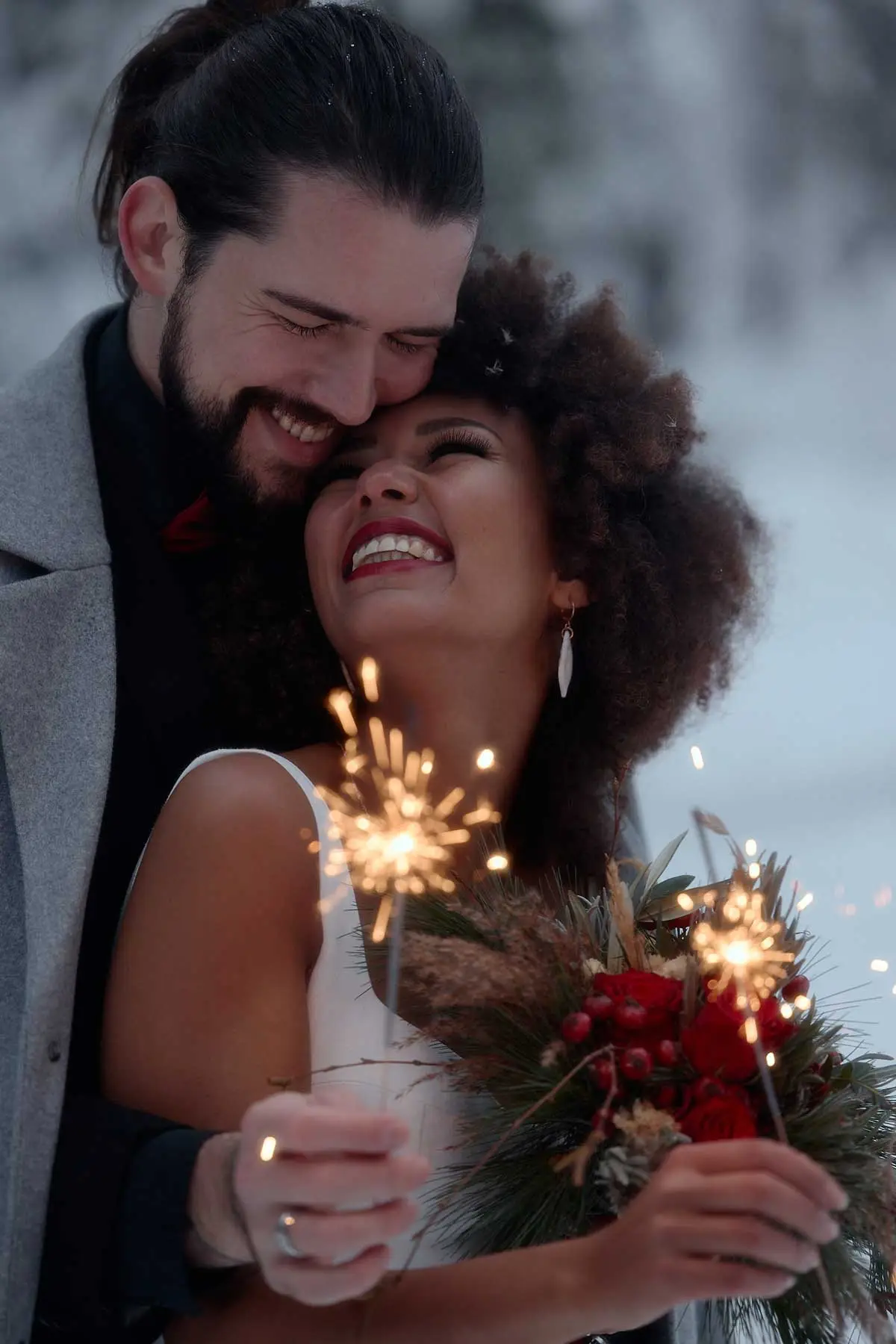 Bride and groom with sparklers in the snow, New Year’s Eve wedding in Switzerland